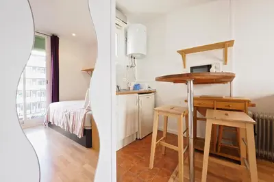 a kitchen with a desk and a bed in a room at Sunny Apartments Barcelona in Barcelona