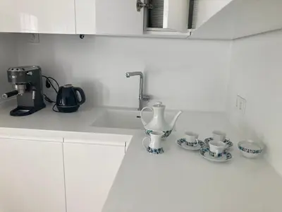 a kitchen counter with a sink and two cups and a mixer at APARTAMENTO 10 MIN SITGES in Puigmoltó