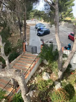 a stairway with a bench and a tree at APARTAMENTO 10 MIN SITGES in Puigmoltó