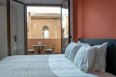 a bed with white pillows in a room with a window at Orange crush Barcelona in Barcelona