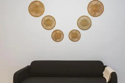 a living room with a couch and four hats on the wall at Orange crush Barcelona in Barcelona