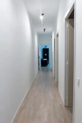 an empty hallway with white walls and wood floors at Orange crush Barcelona in Barcelona