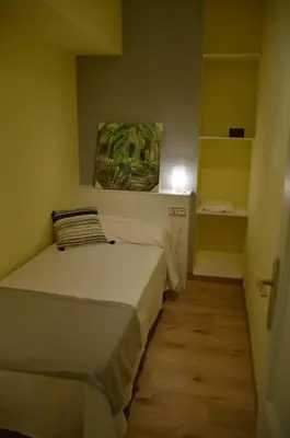 a small bedroom with a bed in a room at Apartamentospedroche Sitges in Sitges