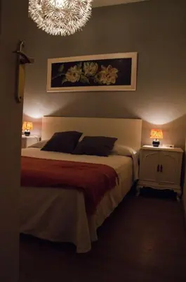 a bedroom with a bed and two night stands with lamps at Apartamentospedroche Sitges in Sitges