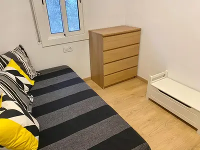 a bedroom with a bed and a dresser in it at Coast apartment near Barcelona in Sant Andreu de Llavaneres