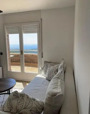 a bedroom with a bed and a view of the ocean at Apartamento entre mar y montaña in Arenys de Munt