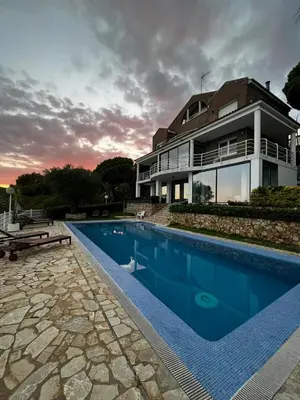 a house with a swimming pool in front of a house at Apartamento entre mar y montaña in Arenys de Munt