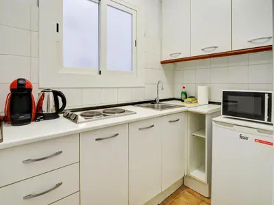 a white kitchen with a sink and a microwave at Espalter Onyx by Hello Homes Sitges in Sitges