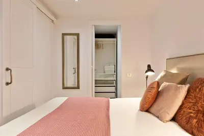 a bedroom with a white bed with orange and pink pillows at Columbus Apartment in Barcelona