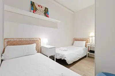 a white room with two beds and a mirror at Bright 3BR2BA w Balcony in Eixample in Barcelona