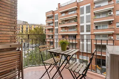 a balcony with a table and chairs and a building at Bright 3BR2BA w Balcony in Eixample in Barcelona