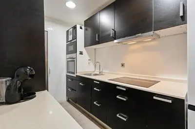 a kitchen with black cabinets and a sink at Bright 3BR2BA w Balcony in Eixample in Barcelona