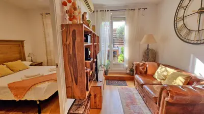 a living room with a couch and a bed and a mirror at Àtic Trobador in Barcelona