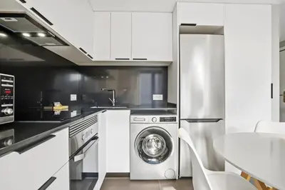 a kitchen with a washing machine and a table at CATERINA Santa Mònica in Barcelona