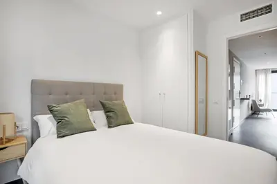 a bedroom with a large white bed with green pillows at CATERINA Santa Mònica in Barcelona