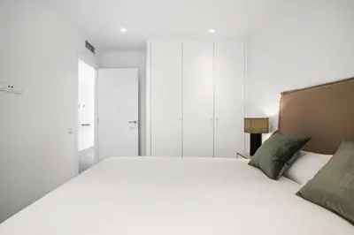a bedroom with a large white bed with green pillows at CATERINA Santa Mònica in Barcelona