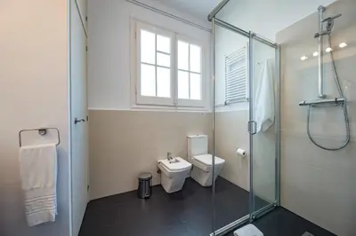 a bathroom with a toilet and a glass shower at Habitat Apartments Bailén in Barcelona