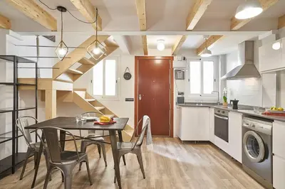 a kitchen with a table and a dining room at BeBarceloner Eixample Duplex Apartments in Barcelona