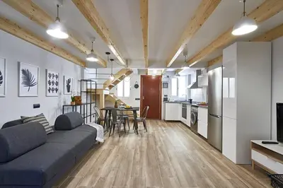 a living room with a couch and a dining room at BeBarceloner Eixample Duplex Apartments in Barcelona
