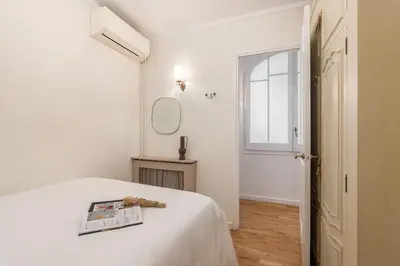 a white bedroom with a bed with a magazine on it at Balmes Apartment by Olala Homes in Barcelona