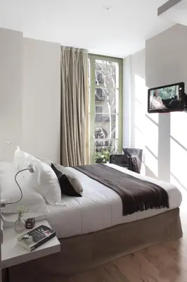 a bedroom with a large bed and a window at Rambla 102 in Barcelona