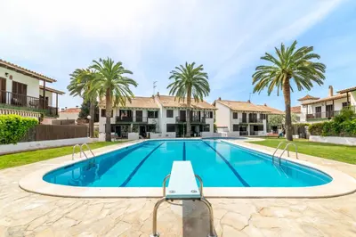 a swimming pool in a villa with palm trees at Paola: Preciosa casa pareada con piscina in Sitges
