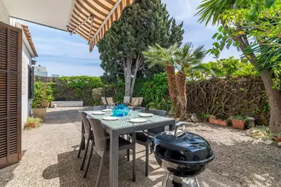 a grill sitting on a table in a backyard at Paola: Preciosa casa pareada con piscina in Sitges