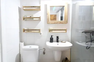 a white bathroom with a toilet and a sink at New design apartment in Barcelona center. in Barcelona
