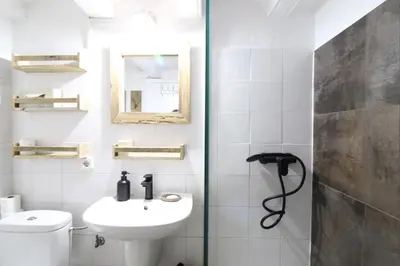 a bathroom with a sink and a toilet and a mirror at New design apartment in Barcelona center. in Barcelona