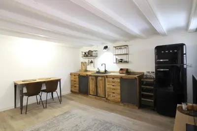 a kitchen with a black refrigerator and a table at New design apartment in Barcelona center. in Barcelona