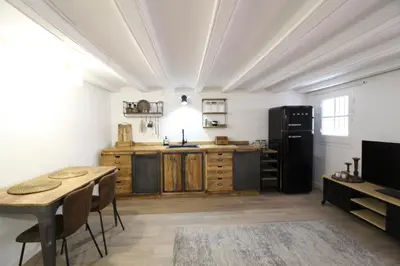 a kitchen with a table and a black refrigerator at New design apartment in Barcelona center. in Barcelona