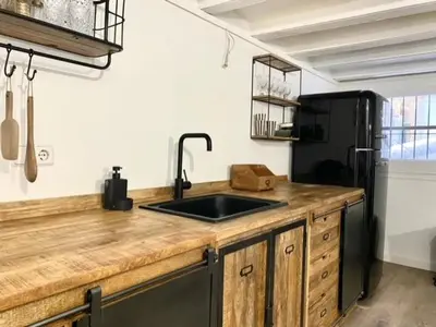 a kitchen with a sink and a black refrigerator at New design apartment in Barcelona center. in Barcelona