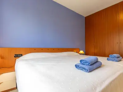 a bedroom with a white bed with blue towels on it at Apartment Girona by Interhome in Cubelles