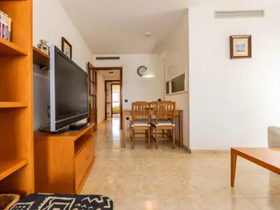 a living room with a television and a dining room at Apartment Girona by Interhome in Cubelles