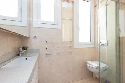 a bathroom with a toilet and a glass shower at ApartEasy - Modernist flat in Eixample center in Barcelona