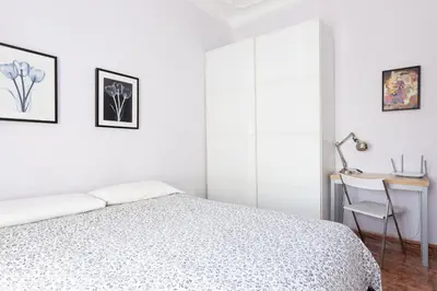 a white bedroom with a bed and a desk at ApartEasy - Modernist flat in Eixample center in Barcelona