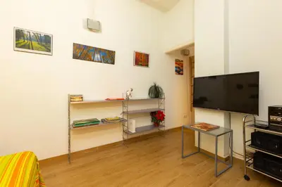 a living room with a flat screen tv on a wall at ApartEasy - Central Barcelona Studio Apartment in Barcelona