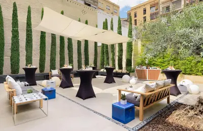 a patio with couches and tables and a fence at H10 Art Gallery 4* Sup in Barcelona