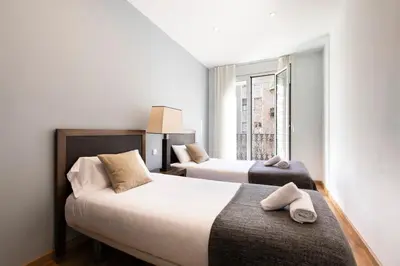 two beds in a room with a window at AB Eixample Miró Park in Barcelona