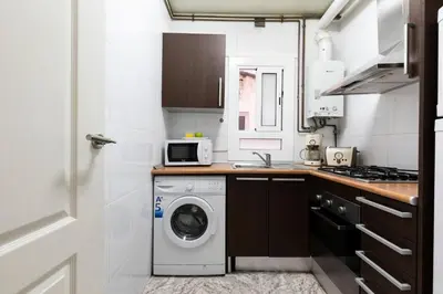 a kitchen with a washing machine and a microwave at AB Eixample Miró Park in Barcelona