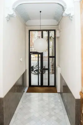 a hallway with a large glass door and a pendant light at Splendid Gaudi Mercat del Ninot Apartment in Barcelona