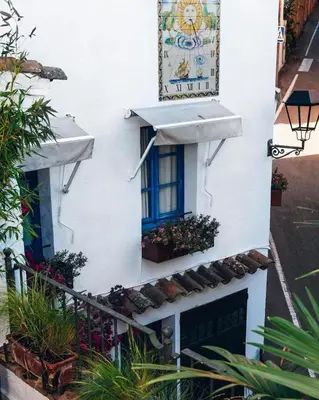 a white building with a window and a sign on it at Hostal de la Plaça - Hotel Boutique in Cabrils