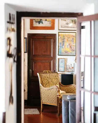 a living room with a chair and a door at Hostal de la Plaça - Hotel Boutique in Cabrils