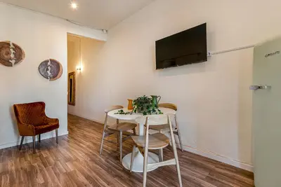 a room with a table and chairs and a tv on the wall at Aragó Suites in Barcelona