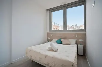 a bedroom with a bed and a large window at BcnStop Sant Pau Suites in Barcelona