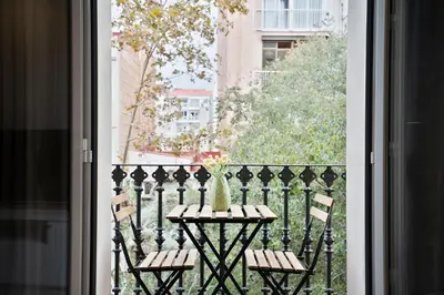 a table and chairs on a balcony with a view at BcnStop Sant Pau Suites in Barcelona