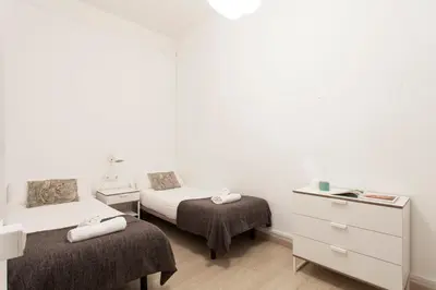 a room with two beds and a dresser in a room at 1554 - AB Passeig de Gràcia Pelai in Barcelona