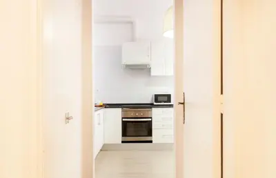 a kitchen with white cabinets and a stove top oven at 1554 - AB Passeig de Gràcia Pelai in Barcelona