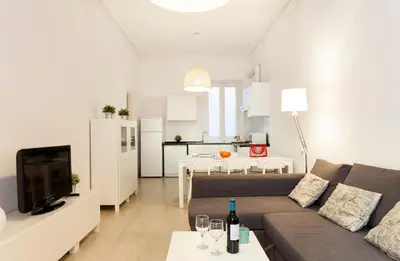 a living room with a couch and a kitchen at 1554 - AB Passeig de Gràcia Pelai in Barcelona
