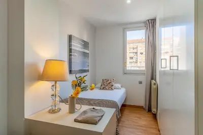 a bedroom with a bed and a table with a lamp at 1520 - AB Eixample Sicília Apartment in Barcelona